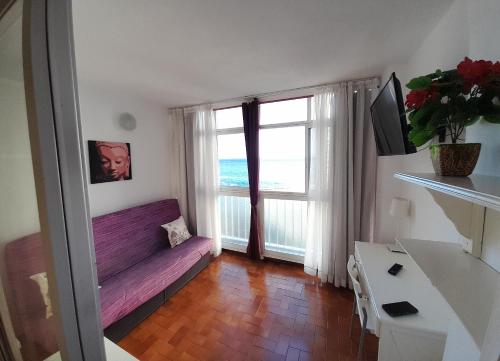 a living room with a purple couch and a window at Paraiso in Tacoronte