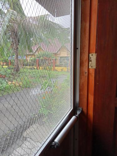 a glass window with a view of a yard at Villa 301 B&B in Baclayon