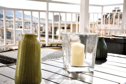 eine Kerze in einer Glasvase auf einem Tisch in der Unterkunft Tiny rooftop apartment in Athen
