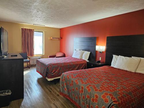 um quarto de hotel com duas camas e paredes vermelhas em Budgetel inn & Suites em Fort Scott