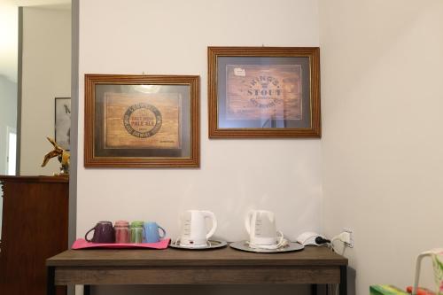 two pictures on a wall with plates on a table at B&B Royal Palace of Napoli & Reggia di Caserta in Caserta