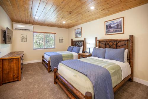 a bedroom with two beds and a wooden ceiling at Tahquitz Pines Retreat in Idyllwild