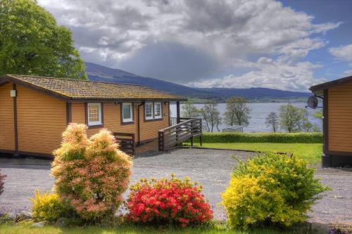 a small cabin with a view of a lake at Appin Holiday Homes -Caravans, Lodges, Shepherds Hut and Train Carriage stays in Appin