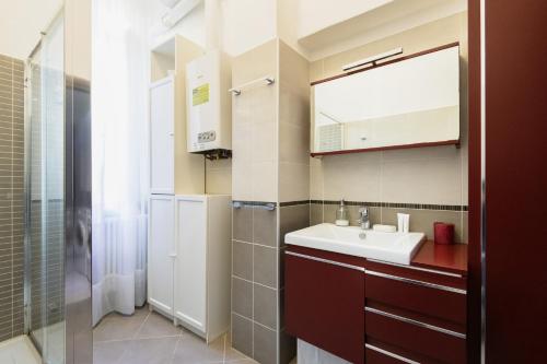 een badkamer met een wastafel, een spiegel en een douche bij Easylife - Oasi di comfort 5 min da Centrale in Milaan