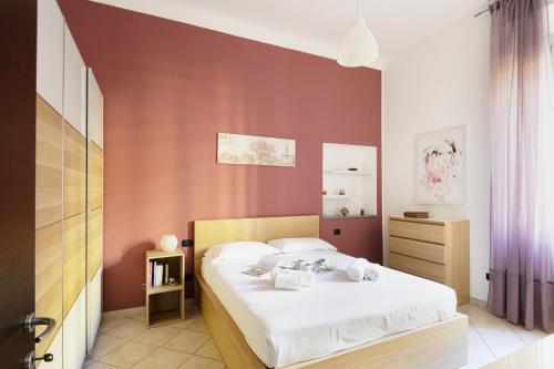 een slaapkamer met een bed met witte lakens bij Easylife - Oasi di comfort 5 min da Centrale in Milaan
