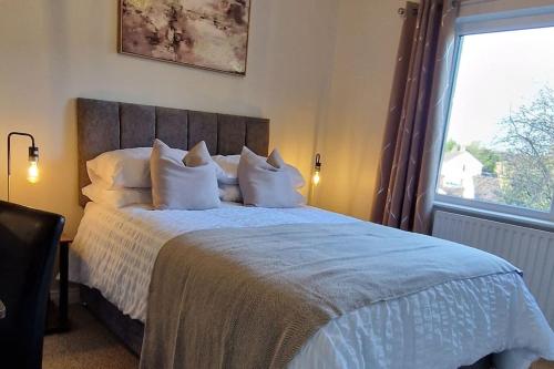Un dormitorio con una cama con almohadas blancas y una ventana en Westland Retreat - Magherafelt - Mid Ulster - NITB Approved, en Magherafelt