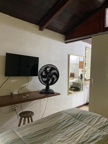 a bedroom with a bed and a flat screen tv at Pousada Casa da Montanha in Angra dos Reis