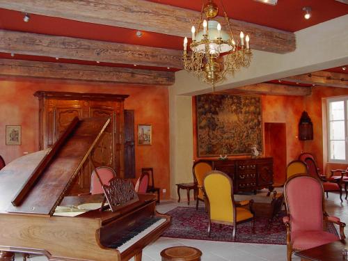 a room with a piano and a table and chairs at Hôtel Du Théâtre Centre Historique - Parking Souterrain Public Gratuit in Metz