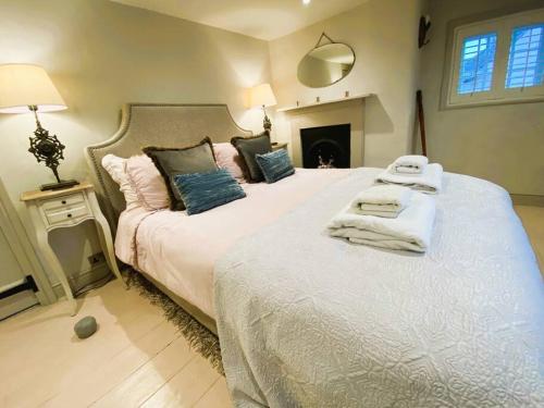 1 dormitorio con 2 camas y toallas. en Stunning Coastal Cottage with free parking - easy stroll to town & beach en Aldeburgh