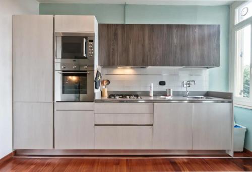 a kitchen with stainless steel appliances and wooden cabinets at Trilocale immerso nel verde in Turin