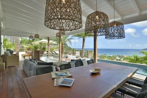 a dining room with a table and a view of the ocean at Villa Nagabaaja in Saint Barthelemy
