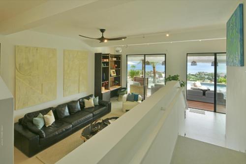a living room with a black couch and a table at Villa Nagabaaja in Saint Barthelemy