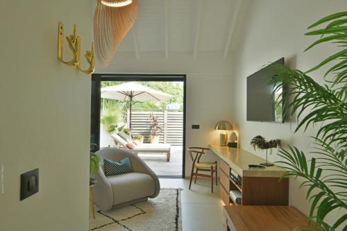 a living room with a chair and a table at Villa Nagabaaja in Saint Barthelemy