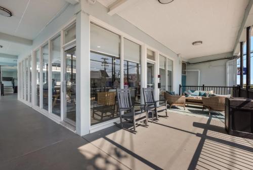 a porch with chairs and a couch and windows at Hotel Cabana Oceanfront/Boardwalk in Wildwood