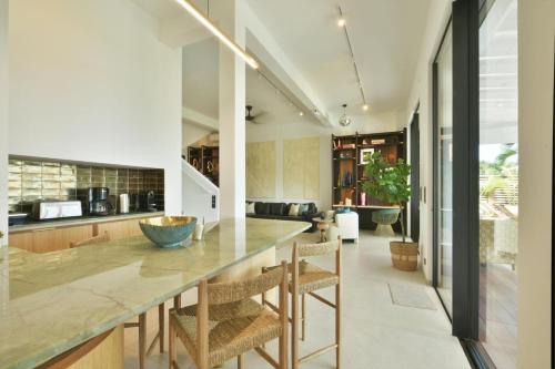 a kitchen with a large counter and chairs at Villa Nagabaaja in Saint Barthelemy