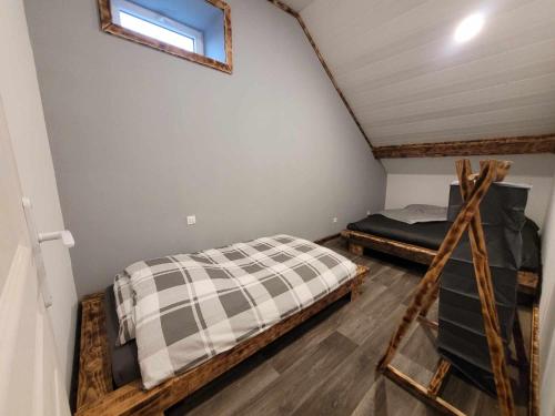 een slaapkamer met 2 bedden op een zolder bij Gîte de la Ferme de la Comté in Le Thillot