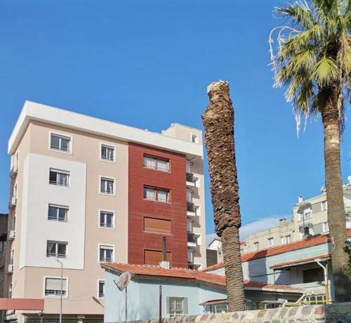 een palmboom en een gebouw met een palmboom bij Ada Apart Otel in Izmir