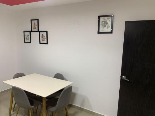 a white table with chairs and pictures on a wall at APARTAMENTO EN VALLEDUPAR in Valledupar