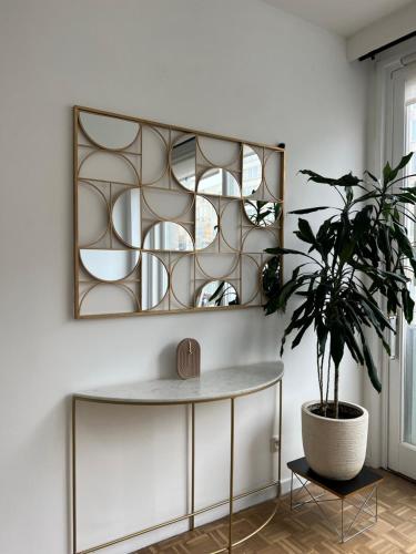 a mirror above a table in a room with a plant at Beautiful new apartment Antwerpen in Antwerp