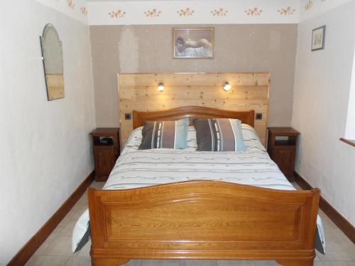 1 dormitorio con cama de madera y cabecero de madera en Gîte Orbey, 2 pièces, 2 personnes - FR-1-744-25, en Orbey