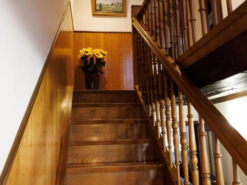 a staircase with a vase with yellow flowers in it at Gîte alsacien rénové avec jardin près de la Suisse et de l'Allemagne, idéal pour familles et amis - FR-1-744-29 in Ueberstrass