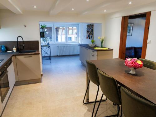 a kitchen with a table with a vase of flowers on it at Gîte alsacien rénové avec jardin près de la Suisse et de l'Allemagne, idéal pour familles et amis - FR-1-744-29 in Ueberstrass