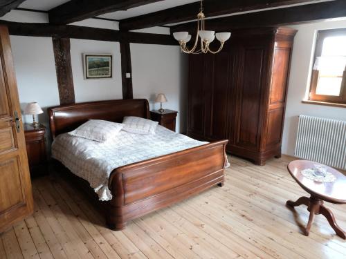a bedroom with a wooden bed and a table at Gîte alsacien rénové avec jardin près de la Suisse et de l'Allemagne, idéal pour familles et amis - FR-1-744-29 in Ueberstrass
