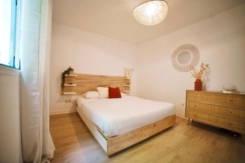 sypialnia z białym łóżkiem i drewnianą komodą w obiekcie Appartemment T2 cosy et spacieux : l’Oasis urbaine w mieście Les Abymes