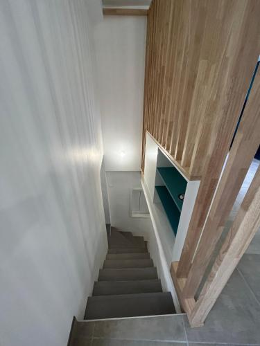 a staircase in a house with white walls and wood at Maison au pied du Château - L’Ange du Château in Champeix