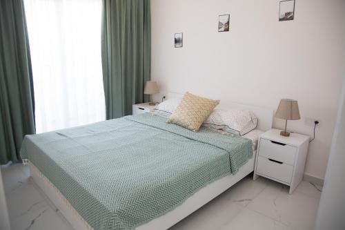 a white bedroom with a bed and a window at Art life aparments (watermelone) in Alanya