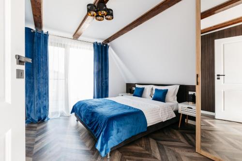 sypialnia z dużym łóżkiem i niebieskimi zasłonami w obiekcie KARL's Cabin by Black & White Panoramic w mieście Rimetea