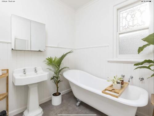 a bathroom with a white tub and a sink at Walnut Cottage in Mildura