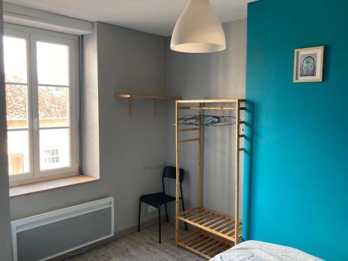 um quarto com uma parede azul, uma prateleira e uma janela em LE CONTI em Corcieux
