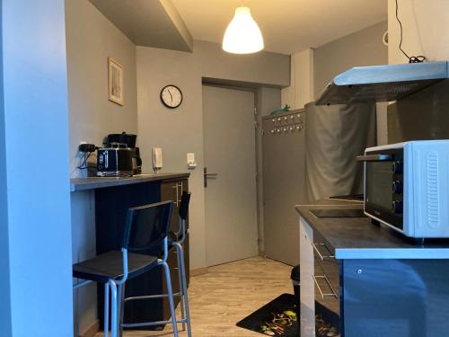 - une cuisine avec un comptoir, un four micro-ondes et un comptoir dans l'établissement LE CONTI, à Corcieux