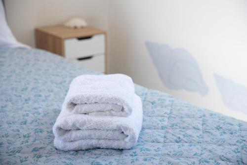 a stack of towels sitting on top of a bed at Navi A2 Brand new Studio in Naousa in Naousa