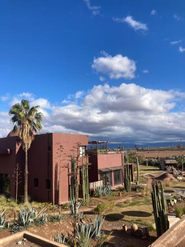 a building with a palm tree in front of it at Fellah Hotel in Marrakech