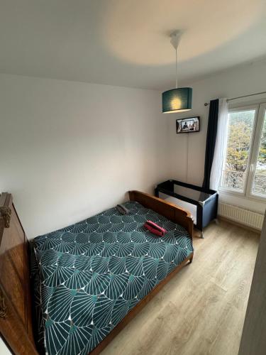 une chambre avec un lit et une fenêtre dans l'établissement Grand appartement, au Havre