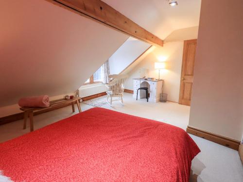 a bedroom with a red bed in a attic at The Bowery in Ambleside