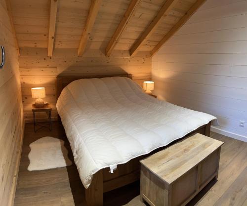 um quarto com uma cama num quarto de madeira em Chalet La Morte em La Morte