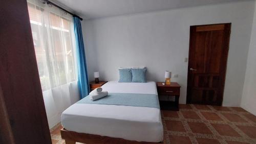 um quarto com uma cama grande e uma janela em Casa THIREMA Tortuguero em Tortuguero