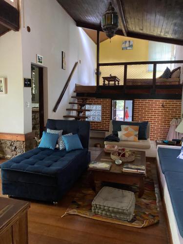 sala de estar con sofá azul y mesa en Pousada Casa da Montanha en Angra dos Reis