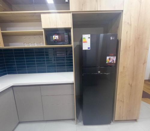 a kitchen with a black refrigerator in a room at Apartamento Luz de Luna2 in La Paz