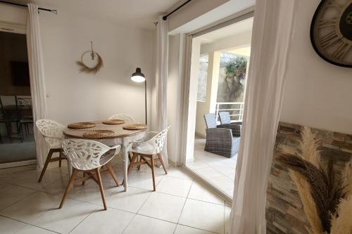 une salle à manger avec une table, des chaises et une horloge dans l'établissement 66 m all comfort in Saint-Raphaël, à Saint-Raphaël