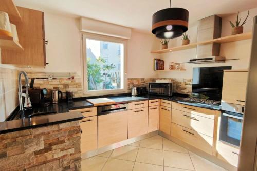 une cuisine avec des armoires en bois et une fenêtre dans l'établissement 66 m all comfort in Saint-Raphaël, à Saint-Raphaël