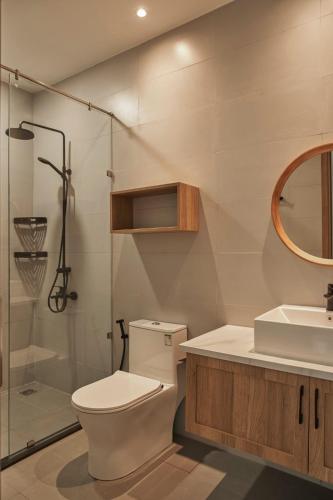 a bathroom with a toilet and a sink and a shower at LAKE HILL Villas in Bao Loc