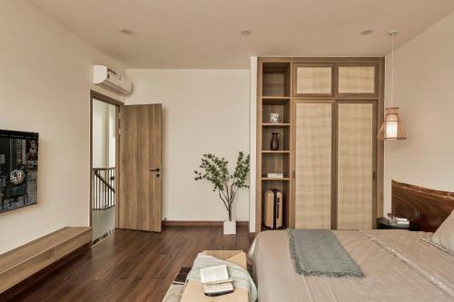 a bedroom with a bed and a book shelf at LAKE HILL Villas in Bao Loc