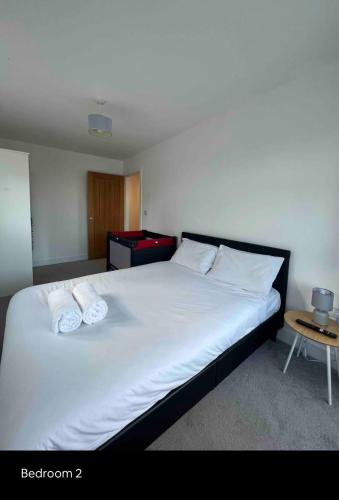 a bedroom with a bed with two pillows on it at White 3 bed bungalow with en-suite and parking in Winford