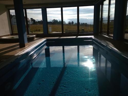 a swimming pool with a view of a field at Hotel Góralski Raj in Nowy Targ