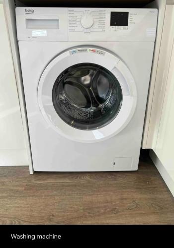 a white washing machine is sitting in a room at White 3 bed bungalow with en-suite and parking in Winford