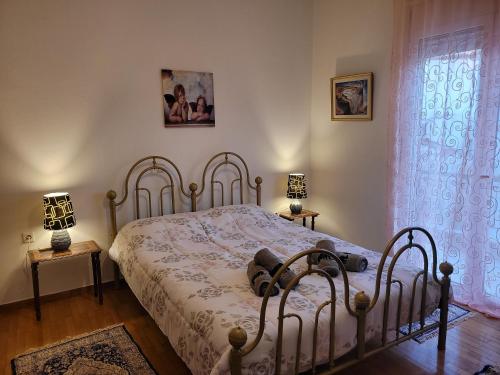a bedroom with a bed and two lamps and a window at City Center Apartment in Arta